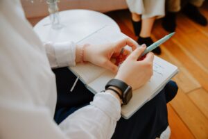 Close-up of a person taking notes during a therapy session, highlighting mental health focus.