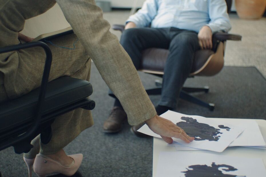 A therapy session with focus on inkblot psychology test and patient interaction.