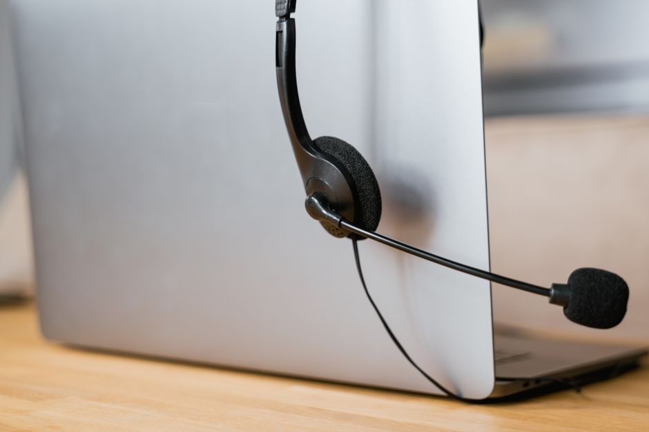 Fone de ouvido e microfone em mesa, ilustrando consulta por telemedicina online